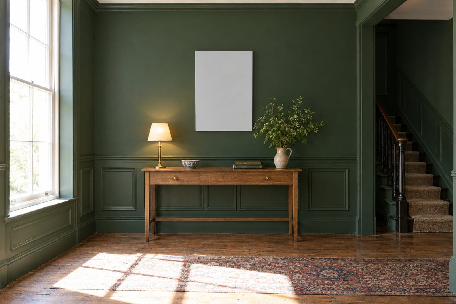 A framed crest hanging above a hall table, on a green panelled wall